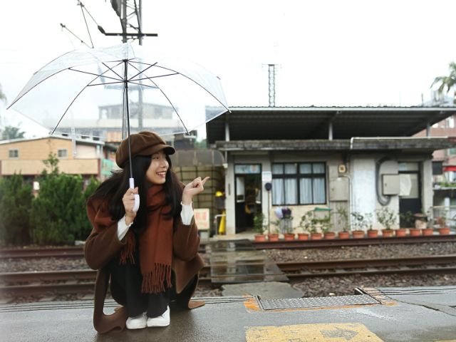駅で傘をさしている人の画像